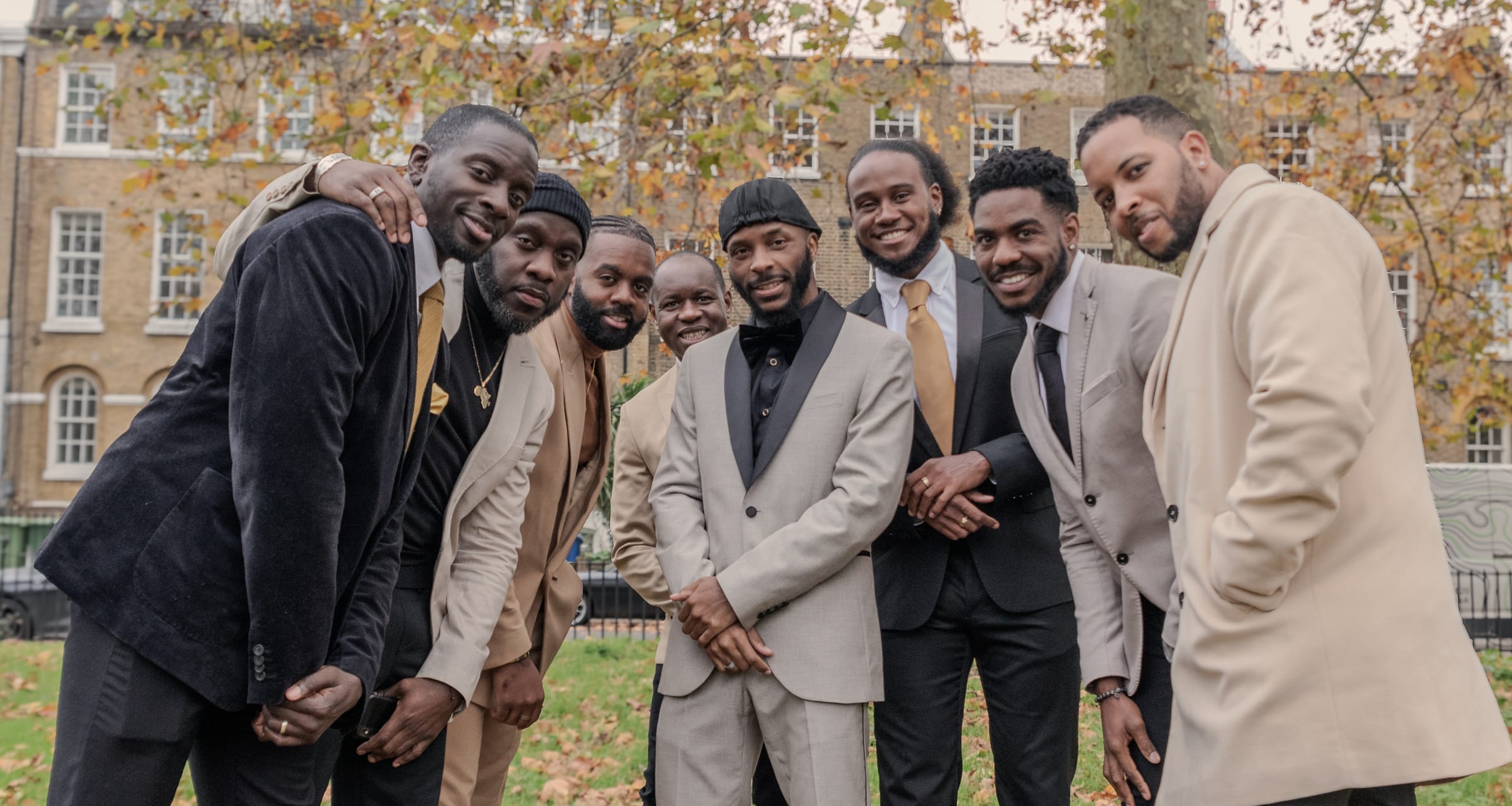 KVG members gathered close together in a London square, arms around each other and smiling