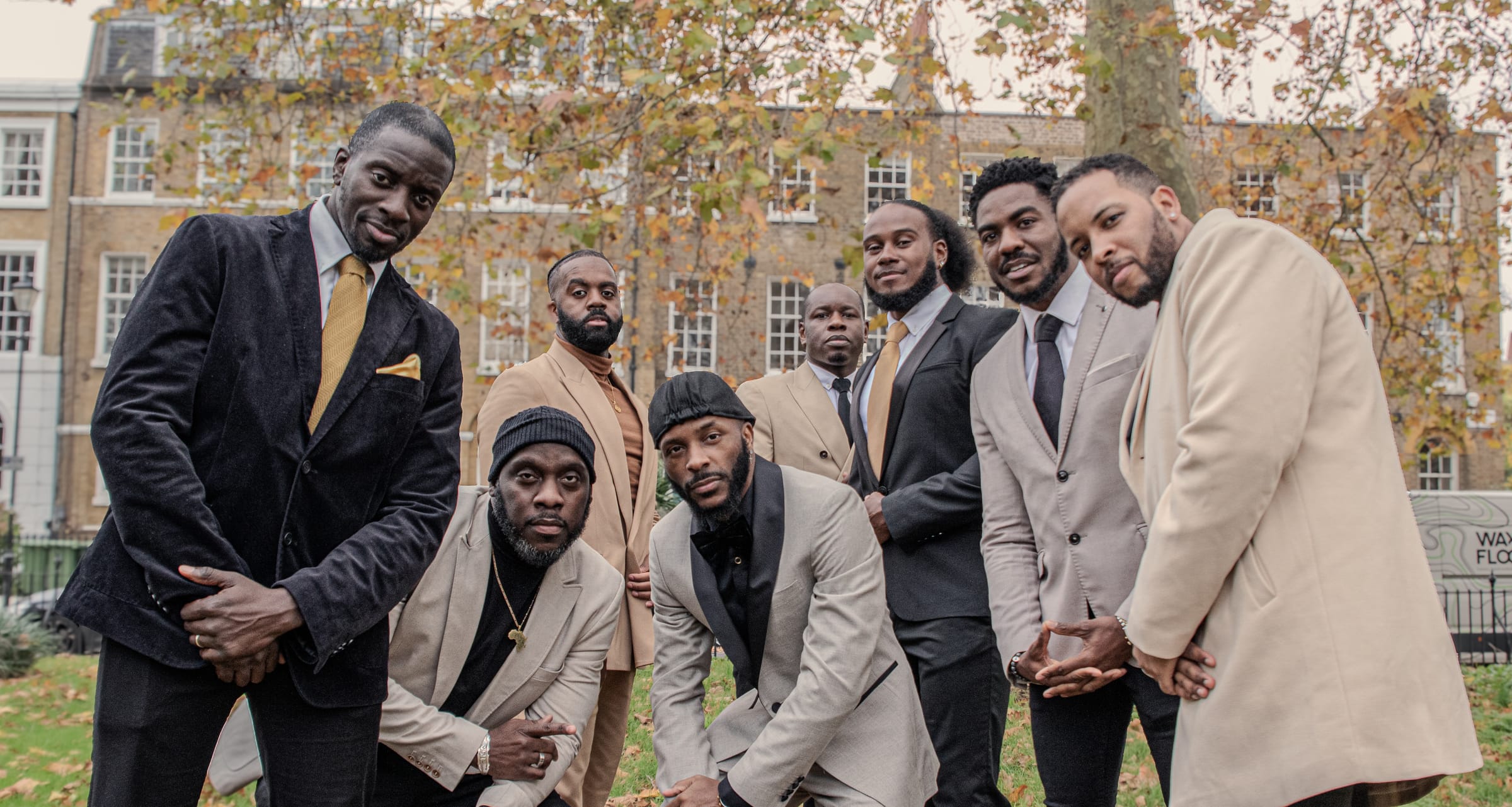 KVG members posing together in a London square, two crouching at the front
